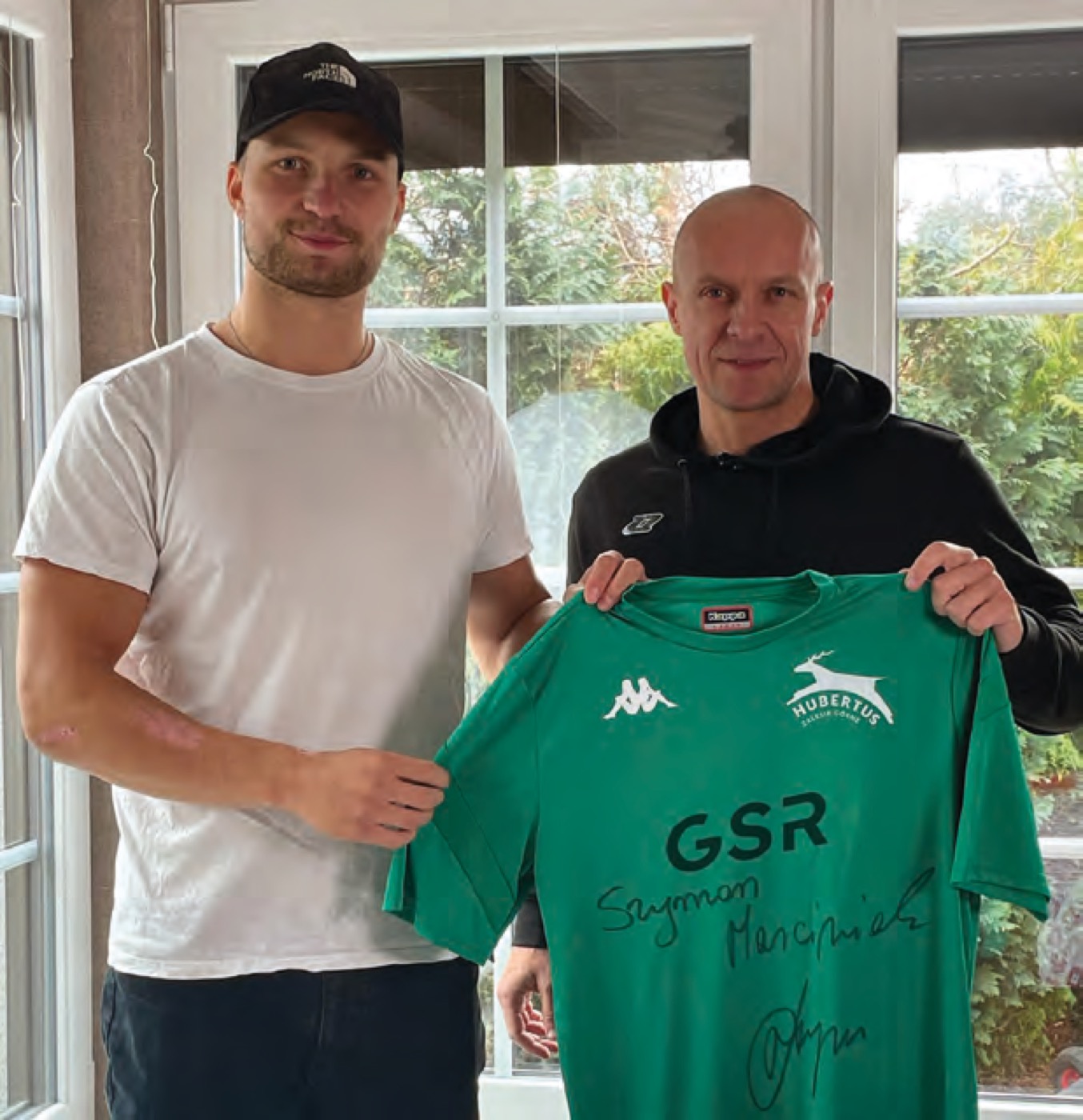 Zespół prezentuje zieloną koszulkę z logotypem GSR — materiał z broszury